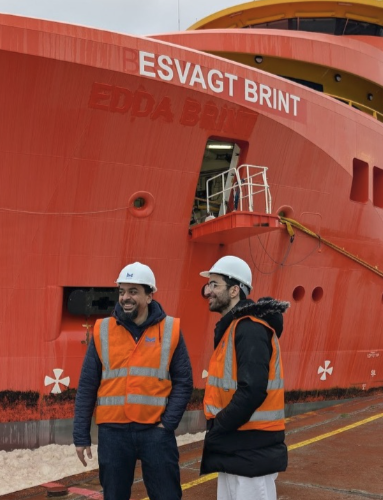 Two port digital twin project team members in safety vests beside the ESVAGT BRIENT vessel